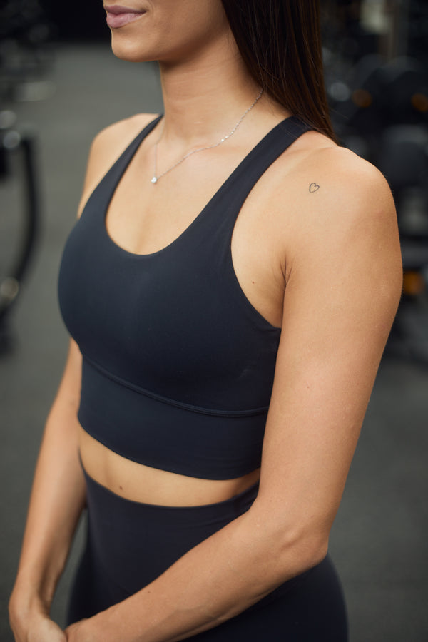 Elise 2.0 Sports Bra in black. Made from high-quality, second-skin material, it is supportive and comfortable. It features a unique open back design; perfect for your next workout or casual wear.