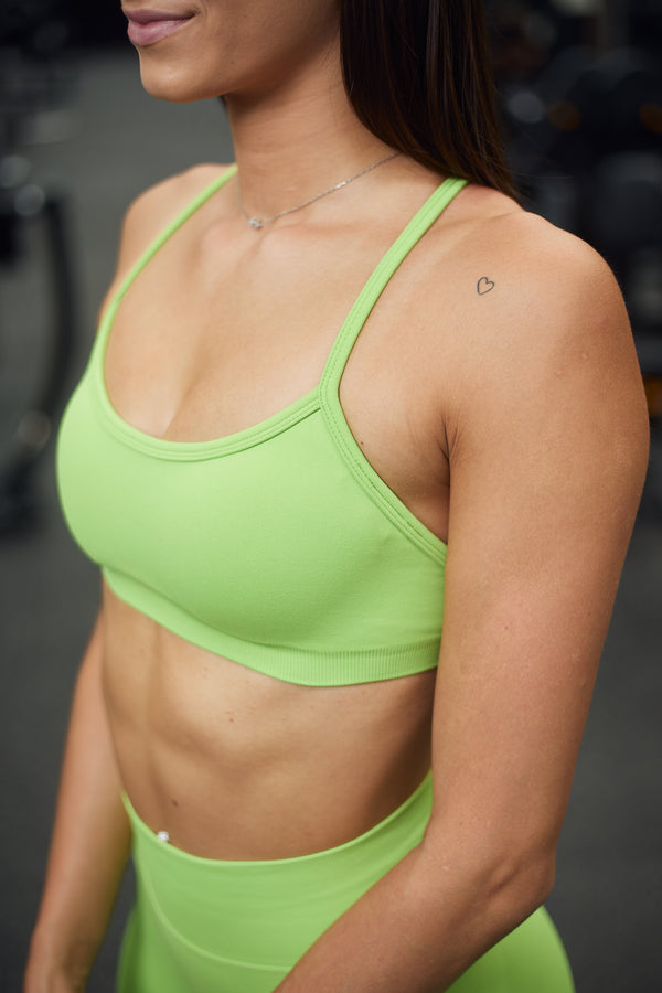 Quore Minimal sports bra in light green. Made from high-quality, seamless material. The bra features a special open back design, adjustable straps, and is padded. Wear it to your next workout or outdoor activity.