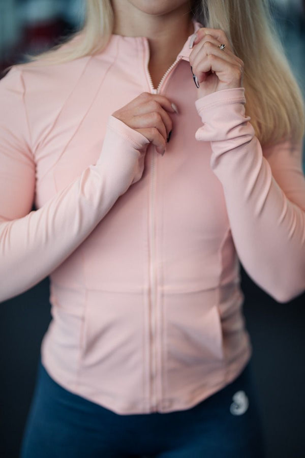 The Essential Jacket for active women, designed to keep warm, cozy, stylish, and elegant. Made from high quality materials, it's soft, stretchy, and comfortable. Features include a printed logo, thumb holes, quality zipper, and a lightweight, fast-drying, breathable fabric.